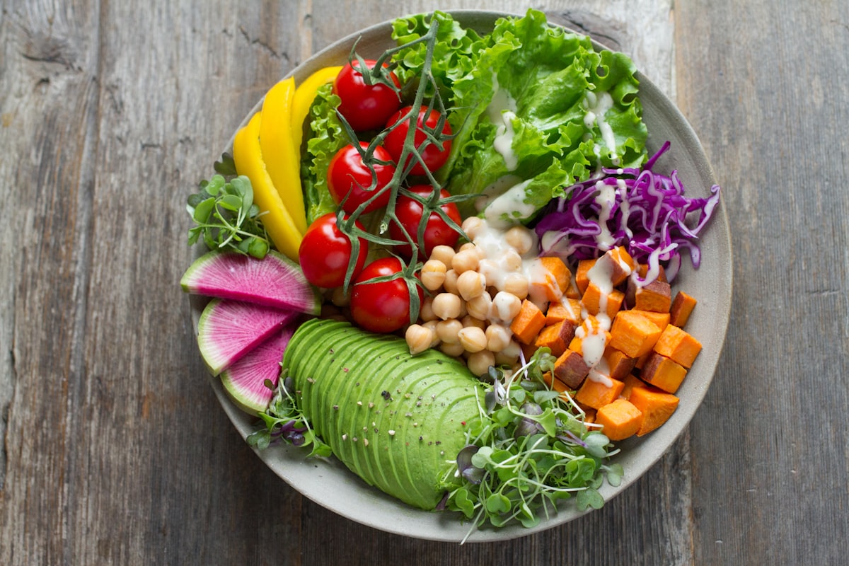 A colorful rainbow Buddha bowl with vegetables, avocado and chickpeas