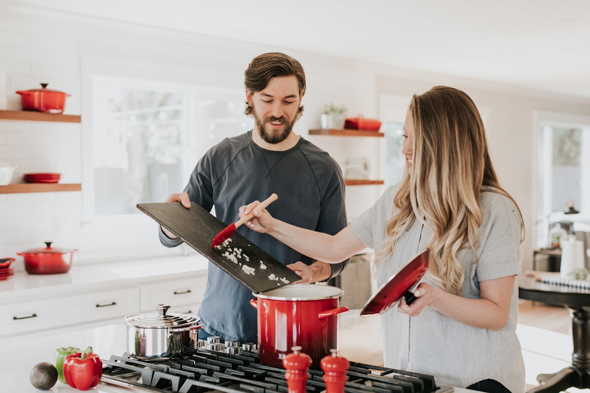A couple cooking dinner together in a bright kitchen