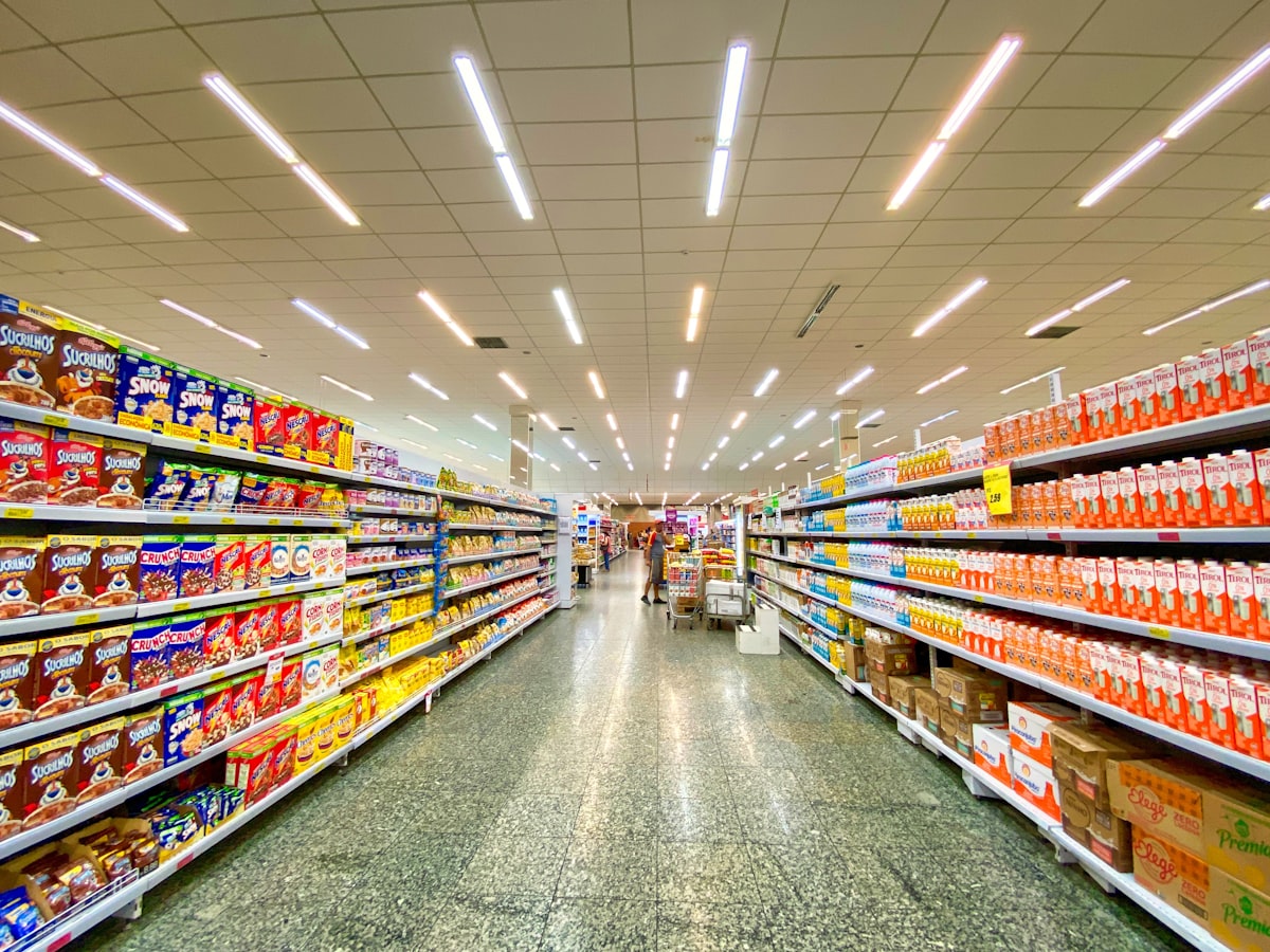A wide supermarket aisle with shelves of packaged foods