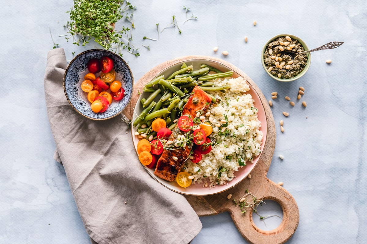 A salmon fillet served with cauliflower rice and green beans